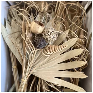 Eksotik šopek z različnimi eksotičnimi sušenimi rastlinami natur barve na beli poglagi.