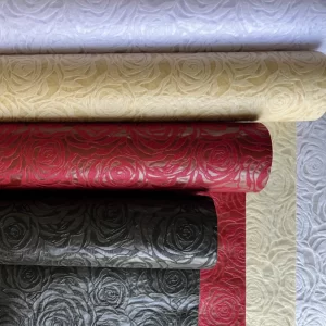 Štiri role ovojnega papirja z vzorcem vrtnice v različnih barvah